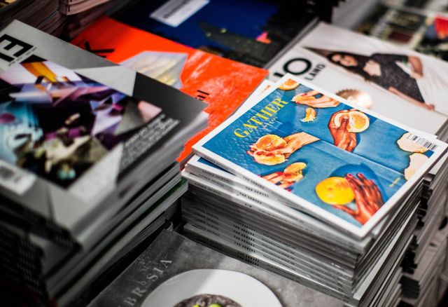 Stack of professionally printed magazines, catalogs and brochures showcasing Moore Printing commercial printing quality